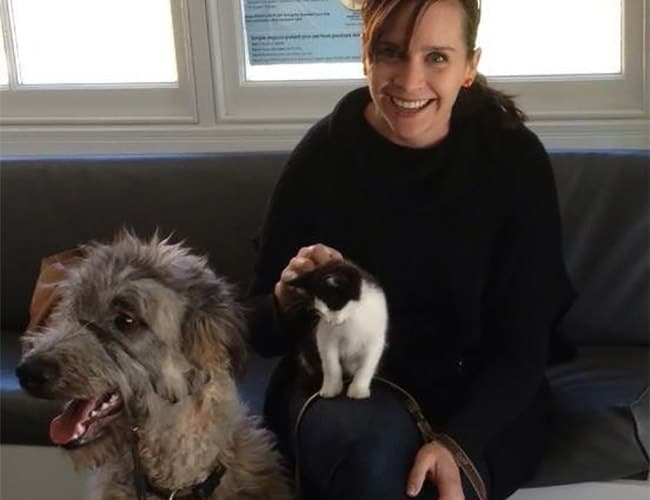 Kristen Jennings is sitting with her cat and dog
